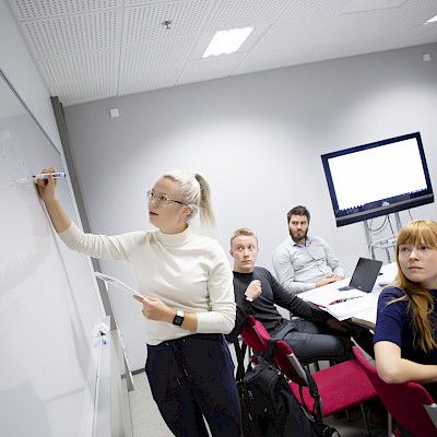 Opiskelijat puhuvat, opettaja kuuntelee